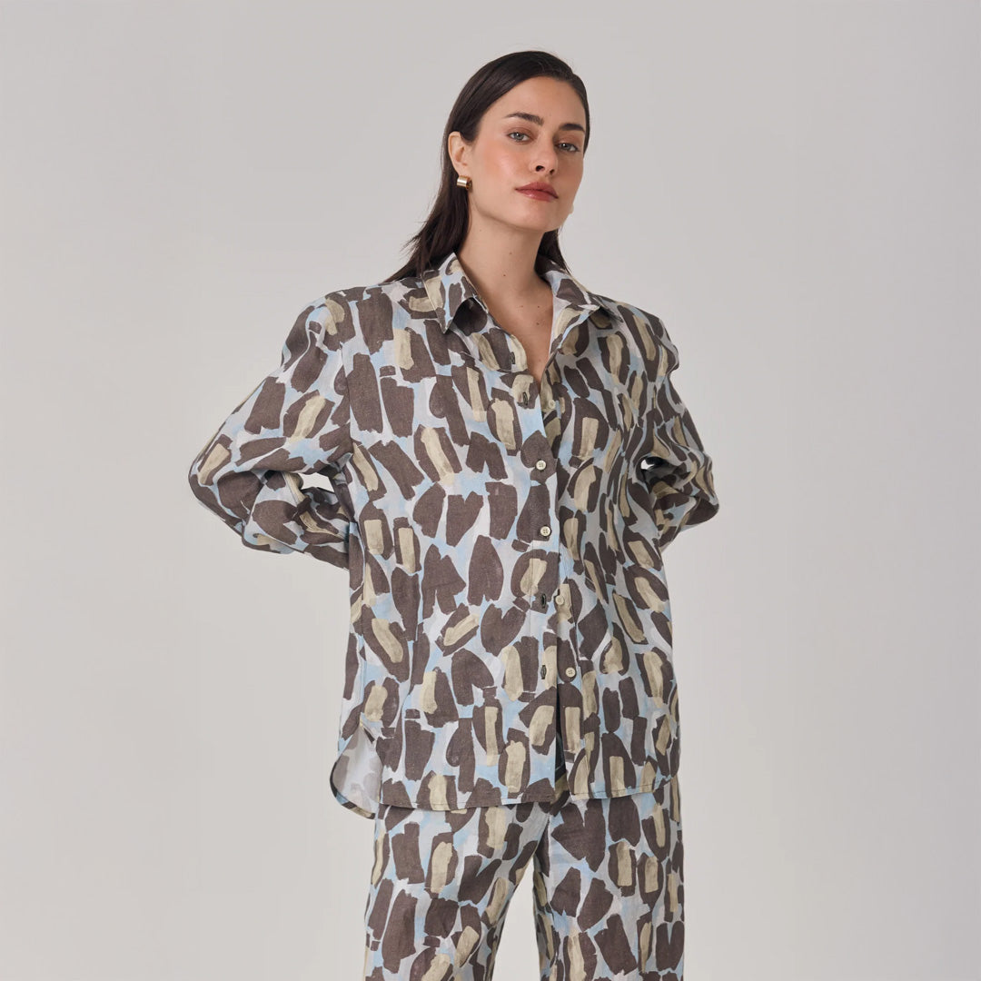 Woman wearing a leopard patterned shirt and pants on a plain background
