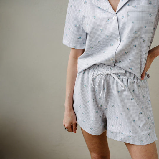 Person wearing a matching pajama set with a light pattern on a neutral background