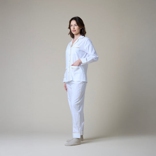 Woman wearing a white pajama against a plain background