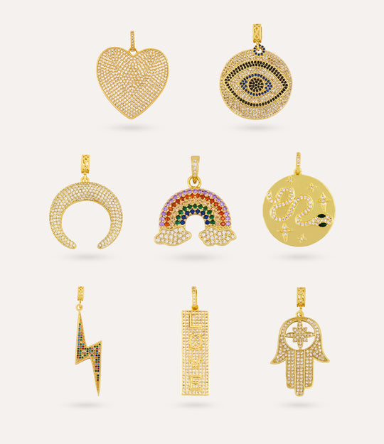 Collection of gold pendants on a neutral background