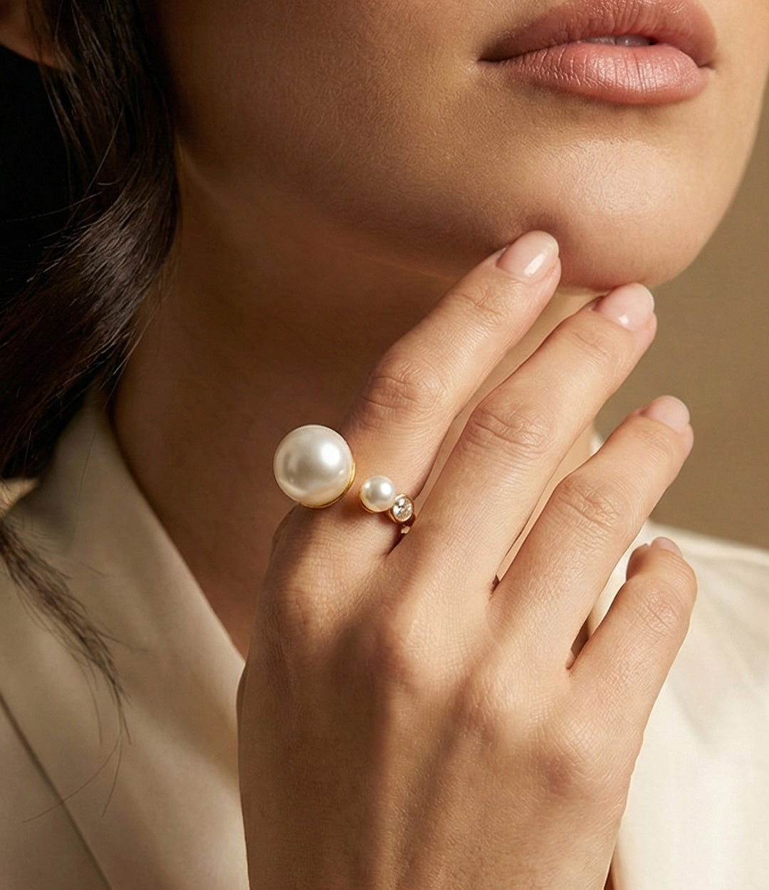 Woman's hand modeling the Asymmetrical Pearl Ring, showing the modern offset design of the pearl and diamond accents on the finger.
