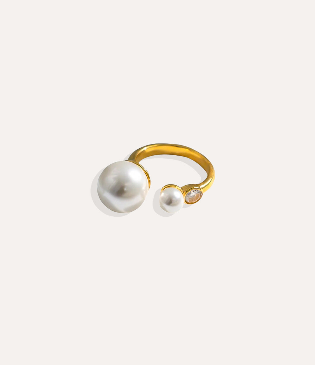 Asymmetrical Pearl Ring in 14k gold plated finish, featuring a single pearl and diamond embellishments on a durable stainless steel band.
