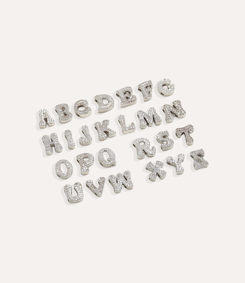 Silver Baby Letter Charms arranged neatly on a white surface, showcasing each initial.