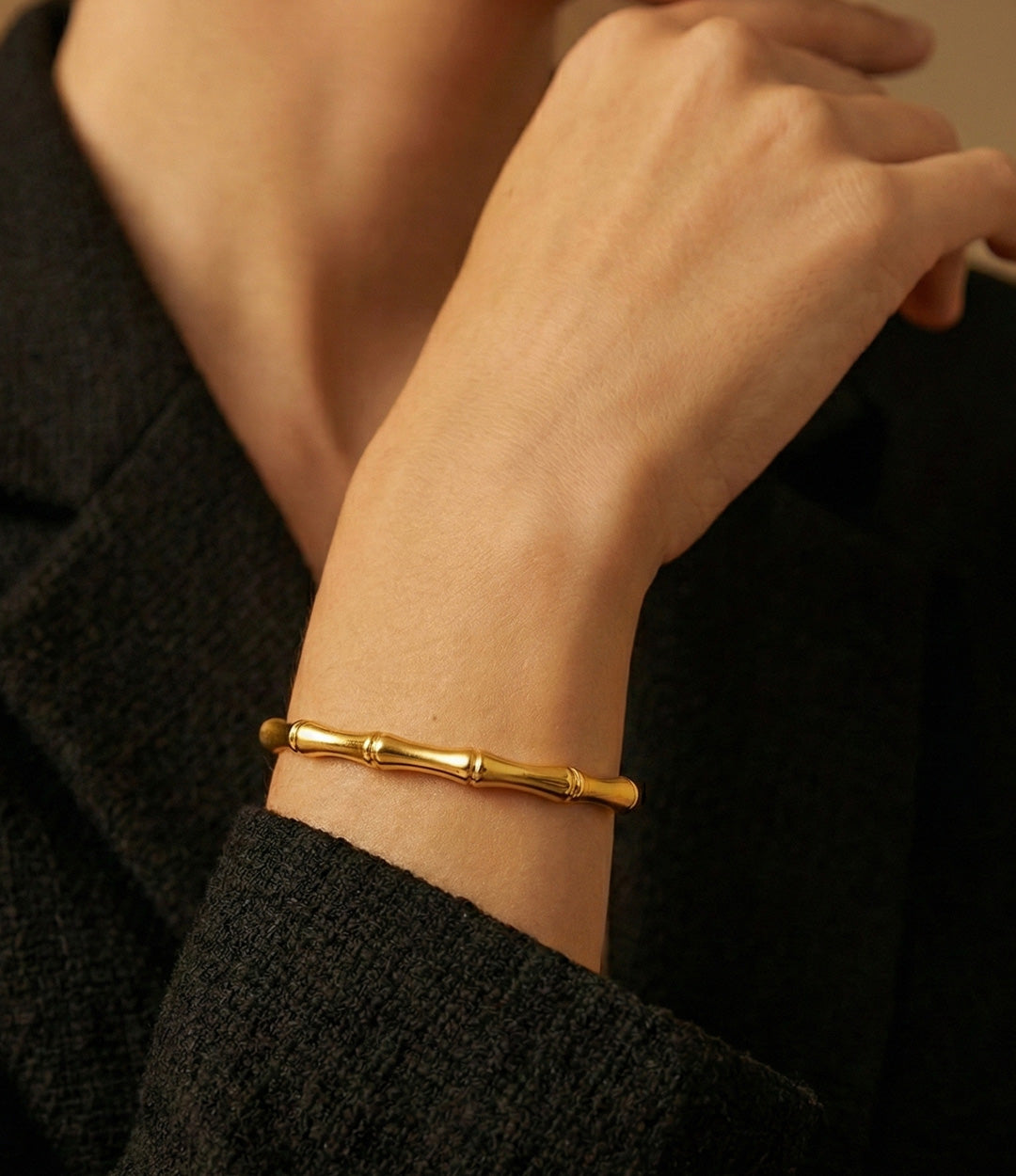 Model wearing the Bamboo Bangle Bracelet in gold.
