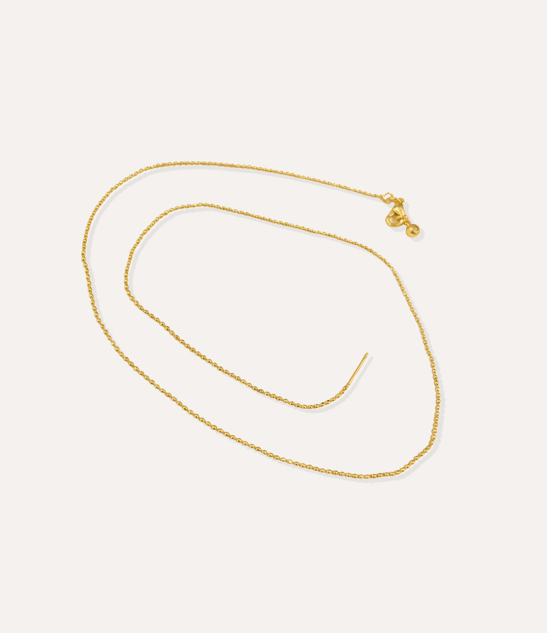 Gold beaded chain necklace displayed on a neutral background with soft lighting.