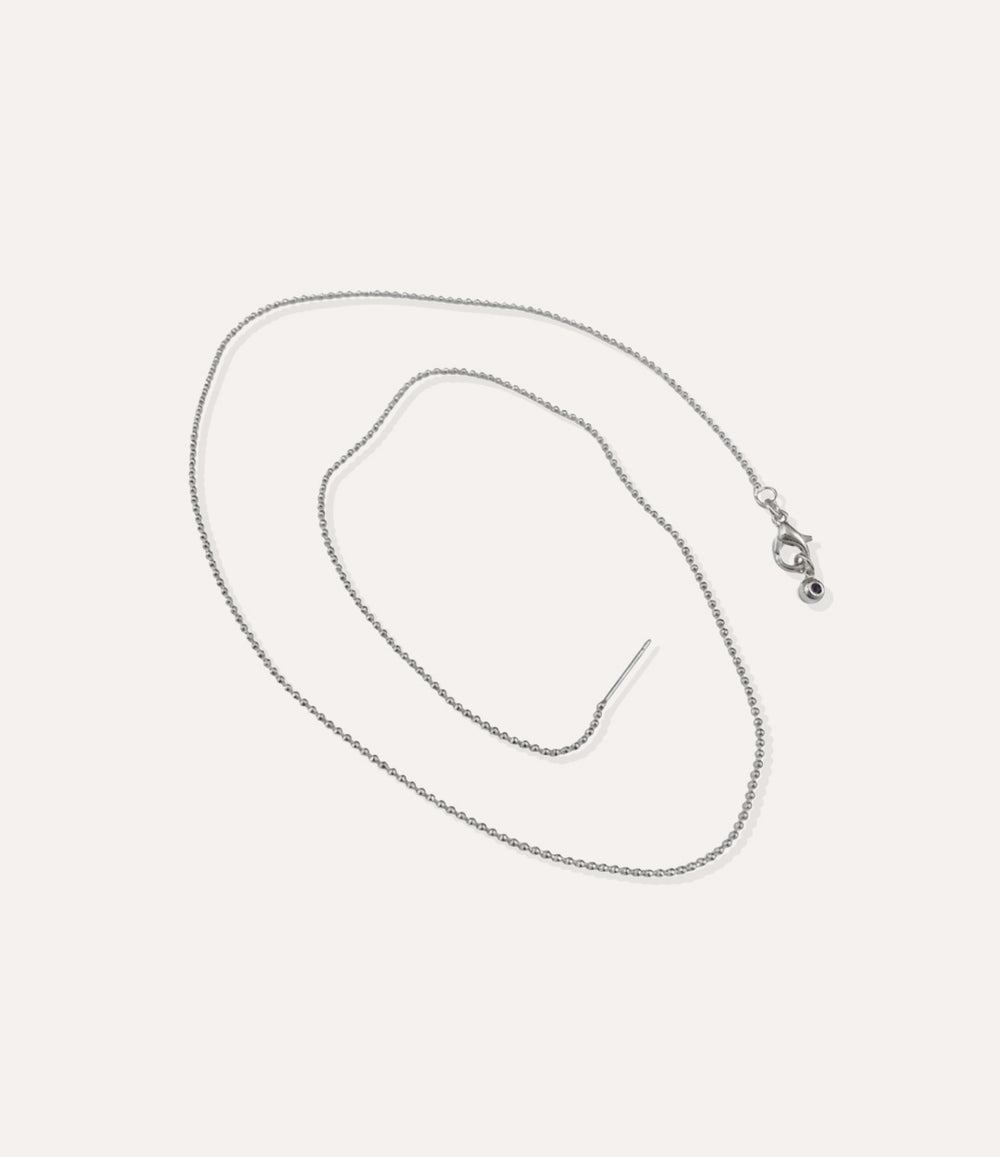 Silver beaded chain necklace displayed on a neutral background with soft lighting.