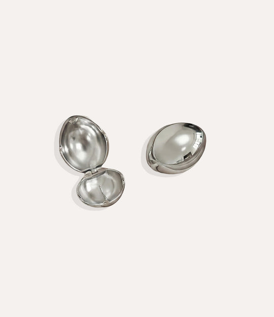 Product shot of the Bianca Earrings in a silver colour showing the cool metallic shine and modern twist shape on a white background.