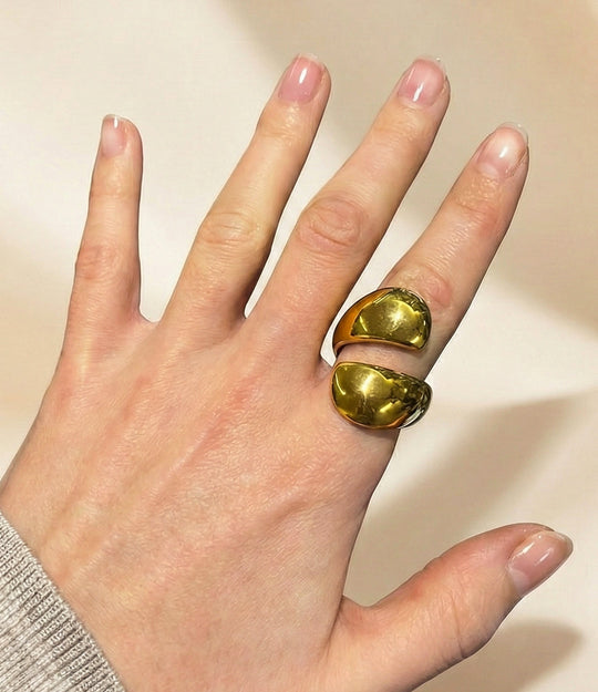 Model wearing Big Hug Ring in 14k gold-plated stainless steel, featuring a thick, fluid wrap-style design isolated on a plain background.