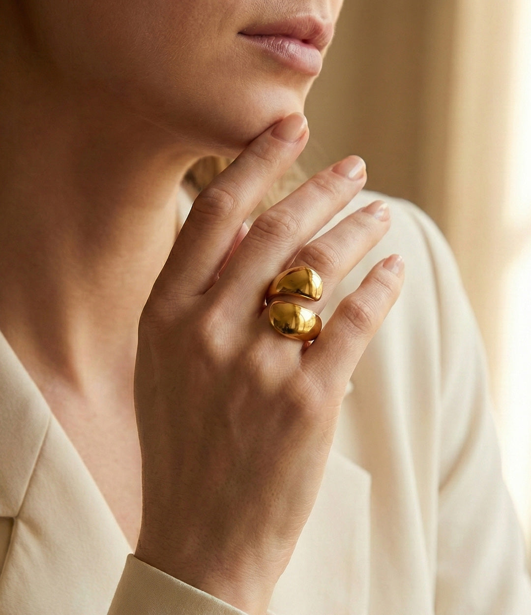 Close-up of a hand wearing a gold ring with a soft focus background