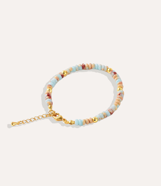 Boho Beaded Bracelet made with natural aquamarine stones, crystals, and 18k gold-plated brass displayed on a neutral background