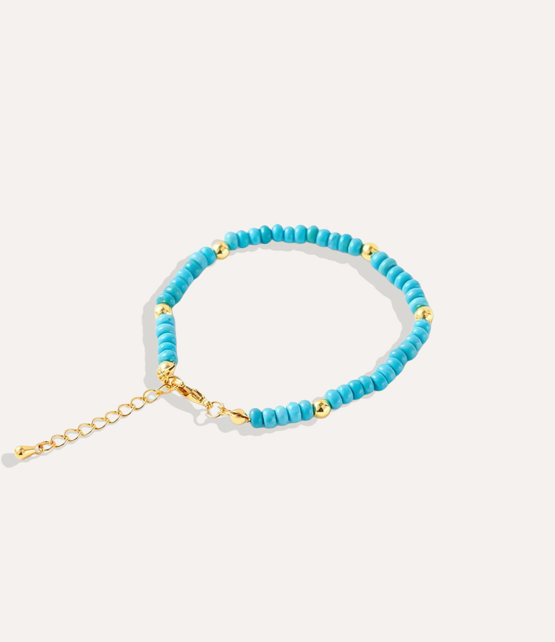 Boho Beaded Bracelet made with natural turquoise stones, crystals, and 18k gold-plated brass displayed on a neutral background