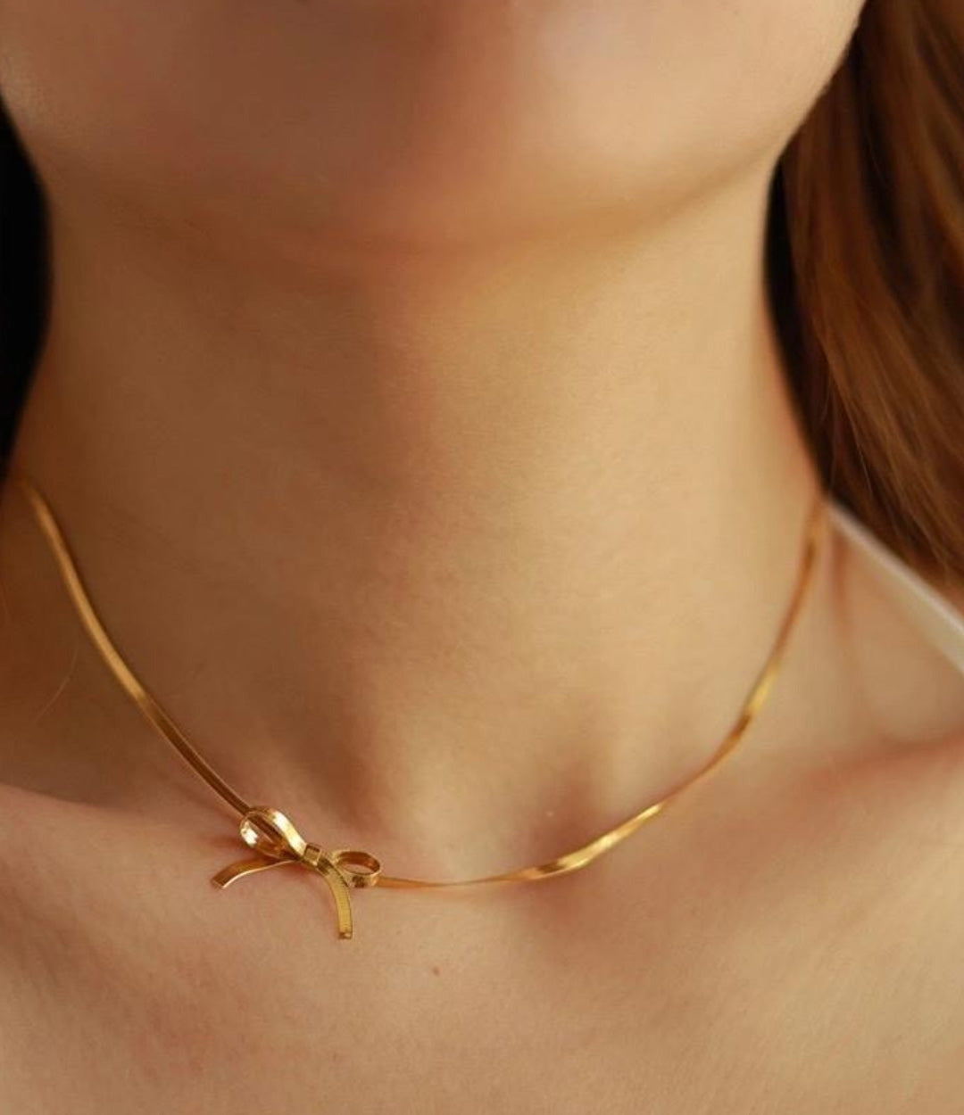 18k gold plated bow necklace on delicate chain styled on model’s neck