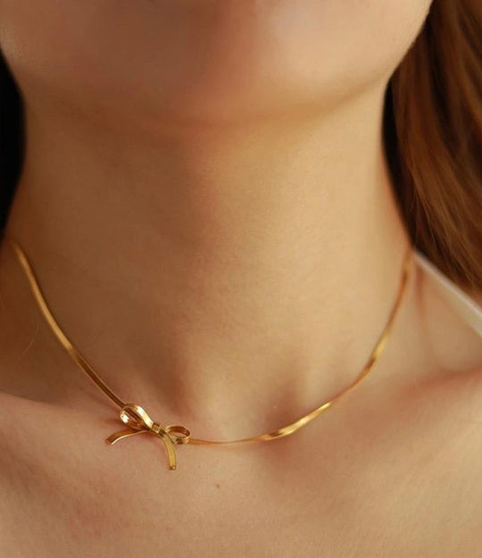 18k gold plated bow necklace on delicate chain styled on model’s neck