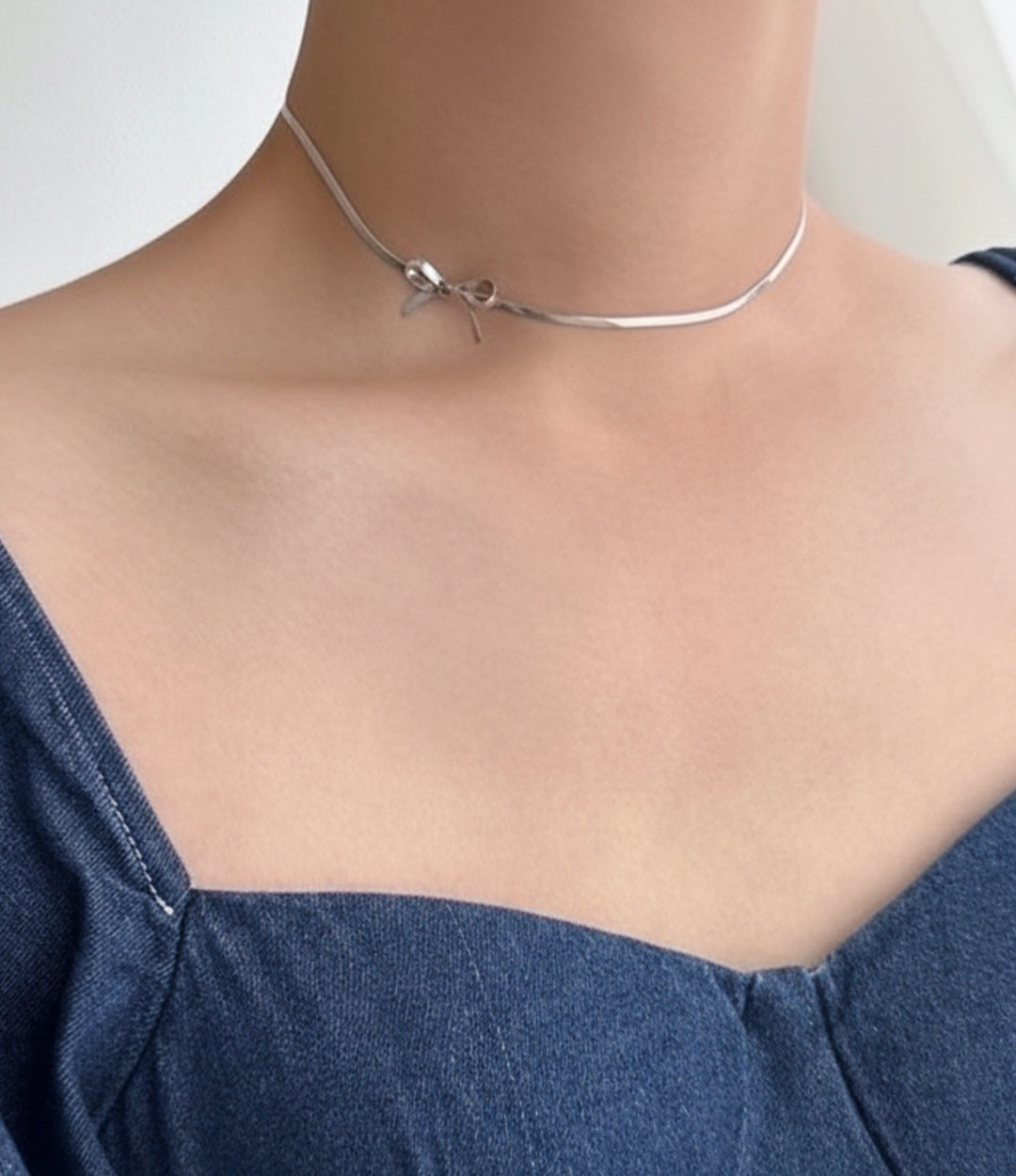 Close-up of water and tarnish proof silver bow pendant necklace