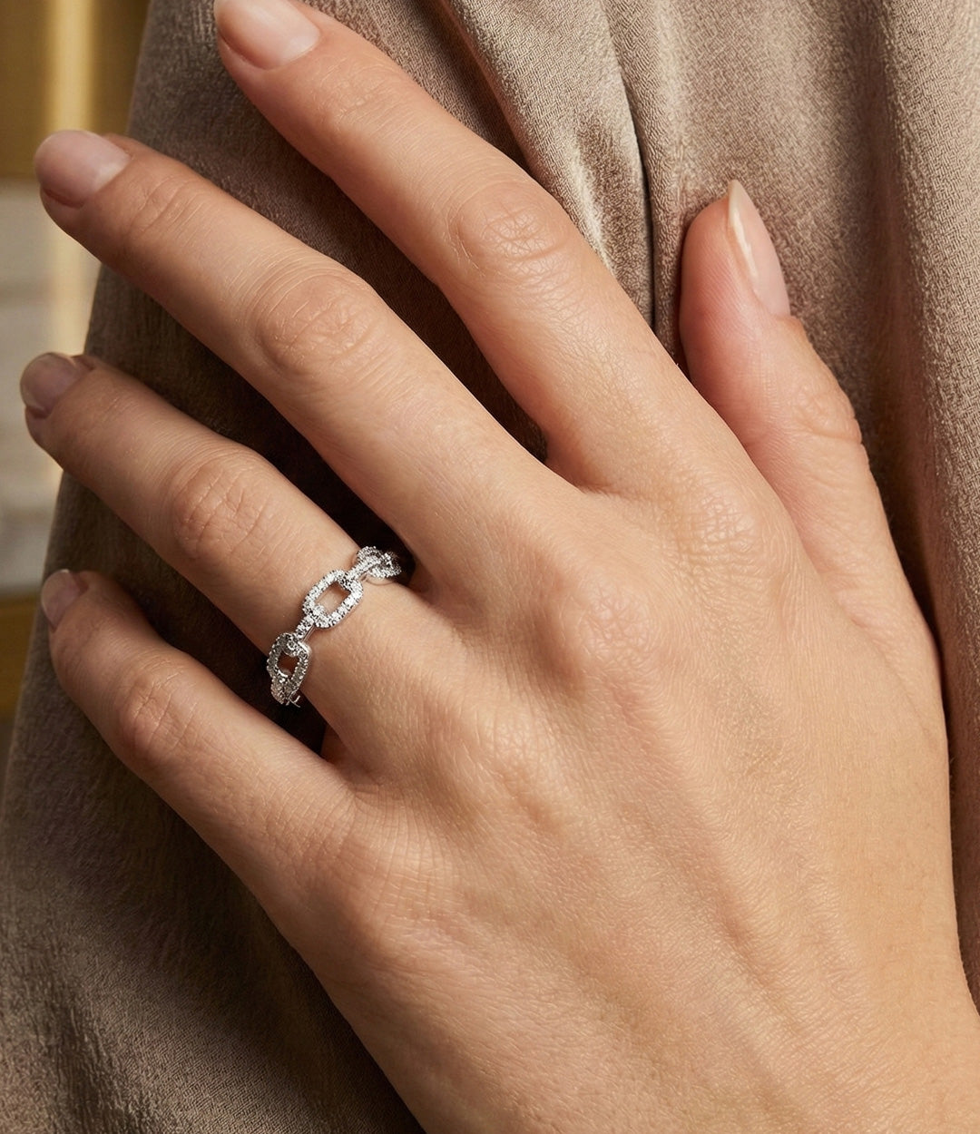 Woman's hand modeling the Chain Link Ring on the ring finger, showcasing the sleek 18k gold plated design and delicate diamond sparkle.