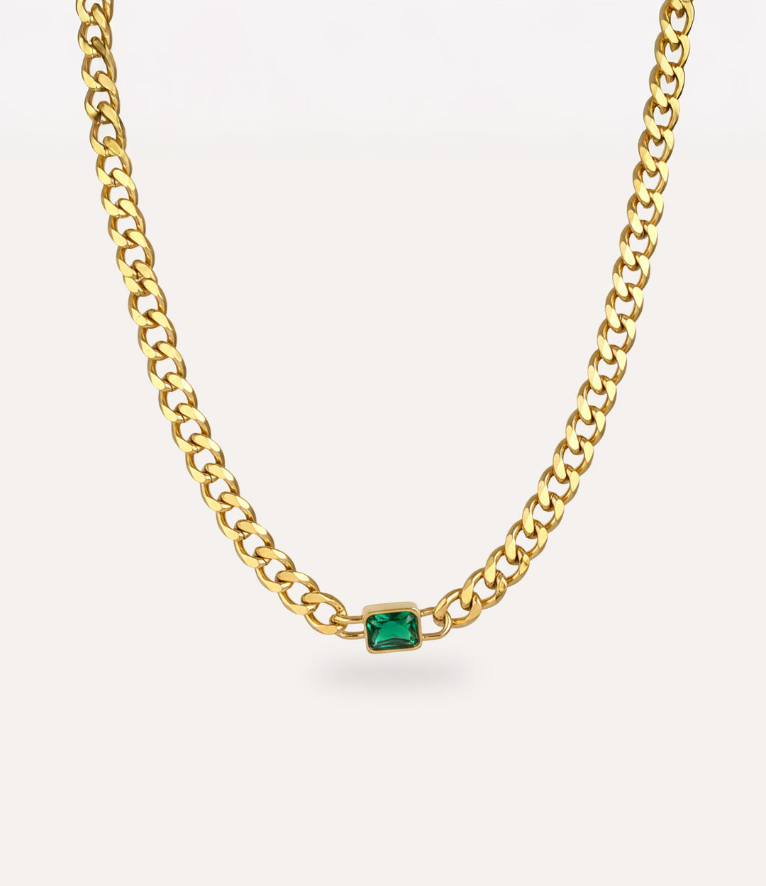 Chunky gold solitaire chain necklace with vintage-inspired green pendant on white background