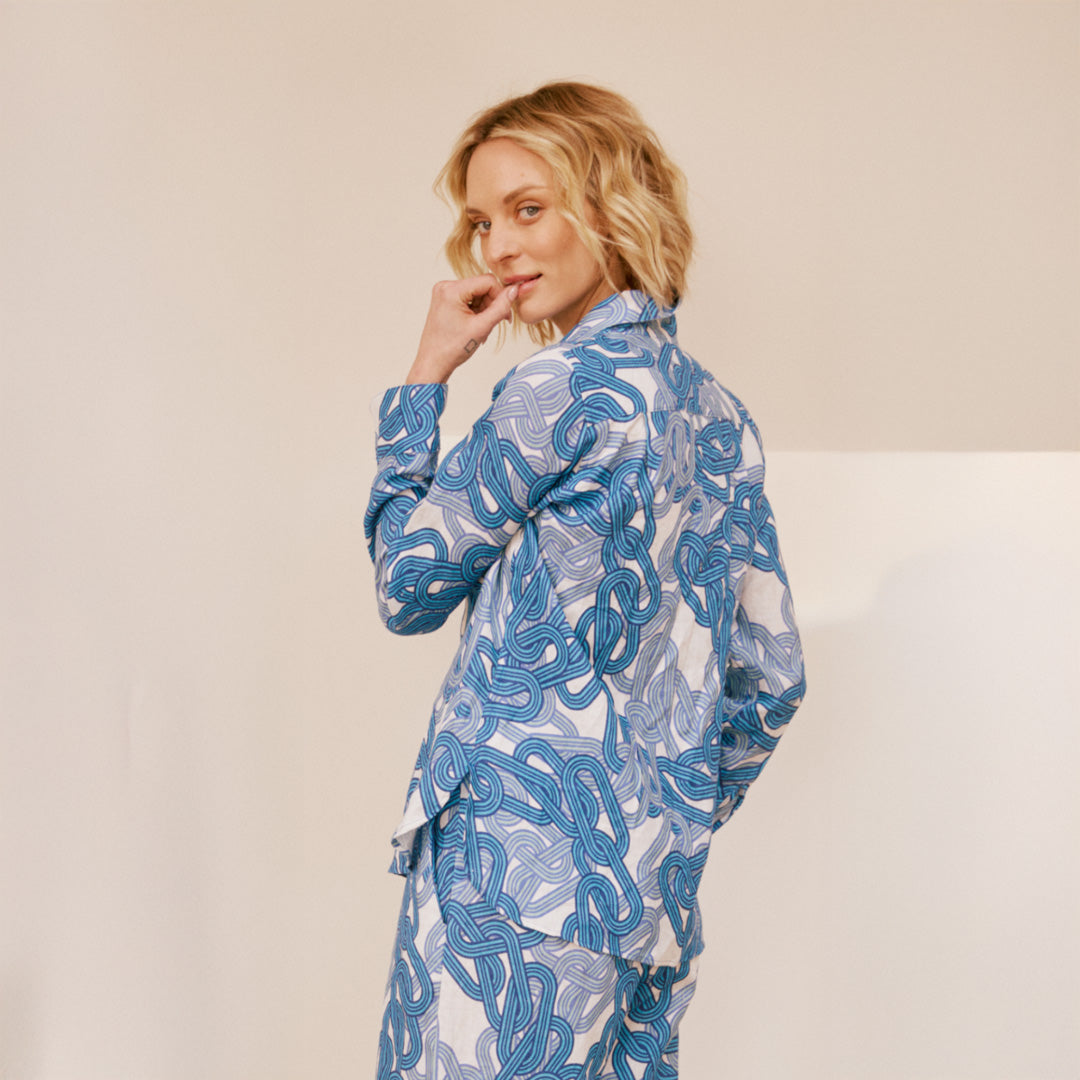 Woman wearing a blue and white patterned outfit on a beige background