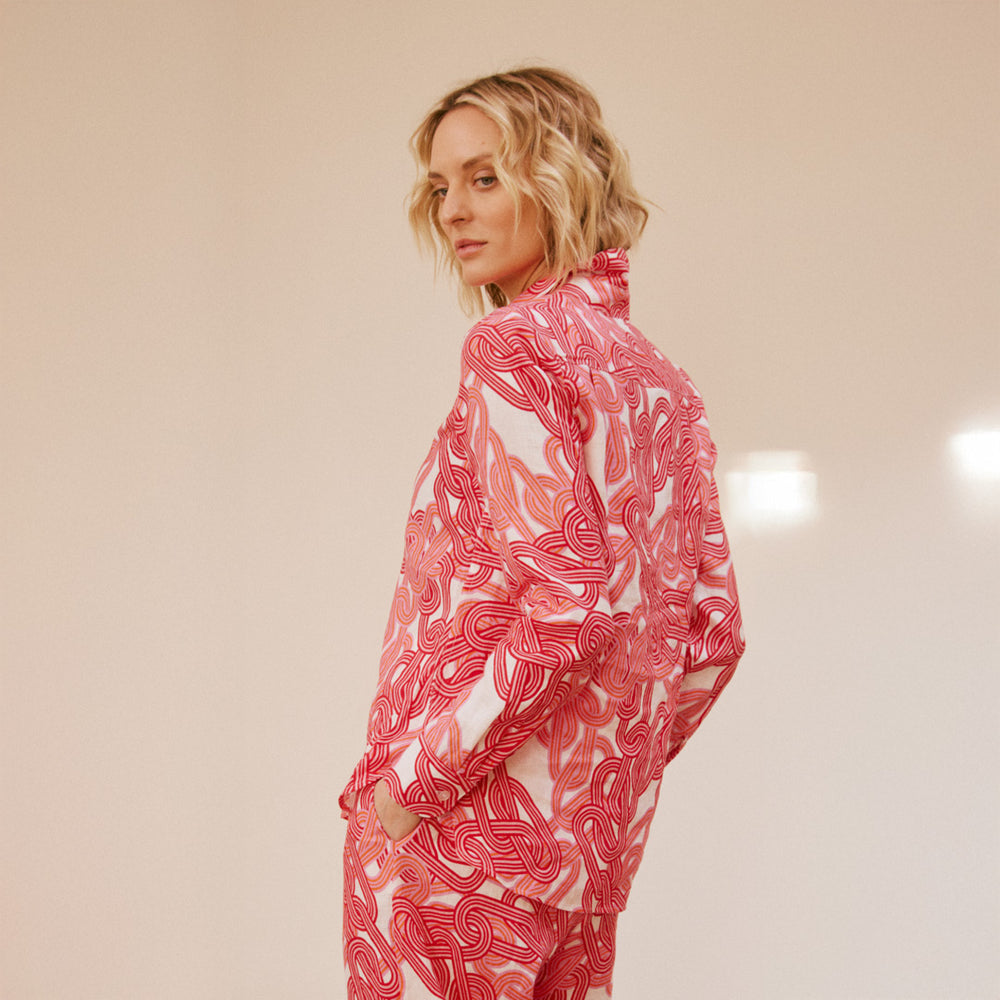 Person wearing a pink and white patterned outfit on a beige background