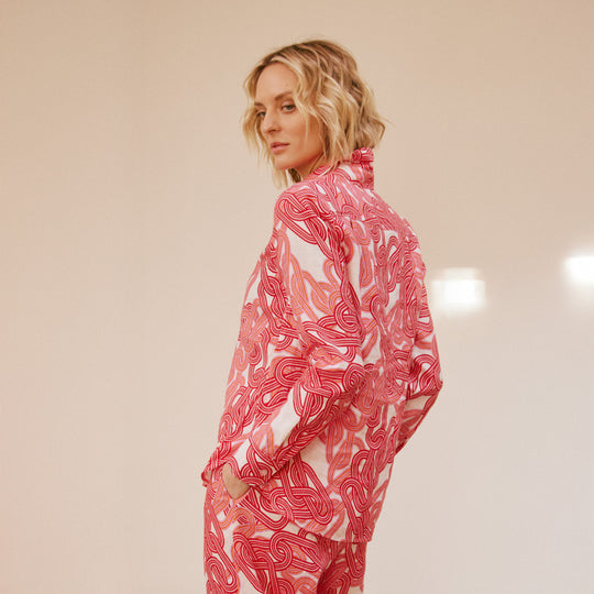 Person wearing a pink and white patterned outfit on a beige background