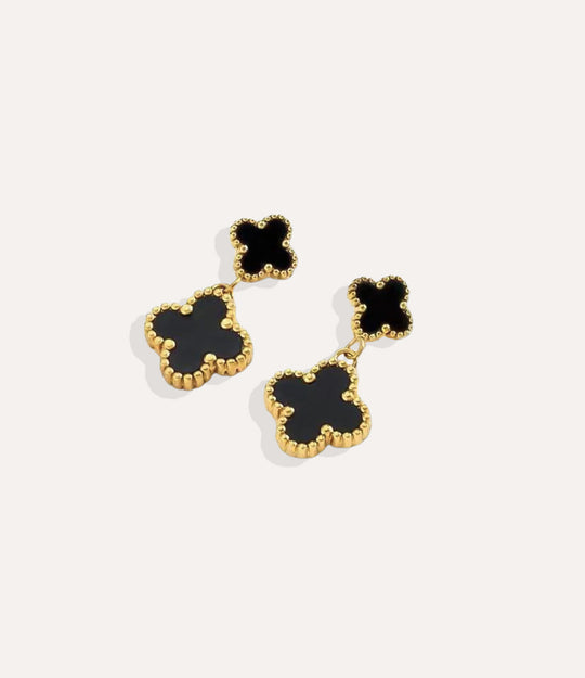 Close up of the black Clover Drop Stud earrings in gold, showcasing the double clover design and dangling detail.