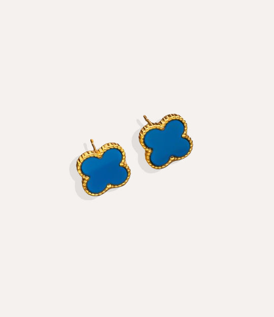 Product shot of the Clover Stud Earrings in a gold finish displaying the lucky four leaf design in blue and warm metallic tone on a white background.