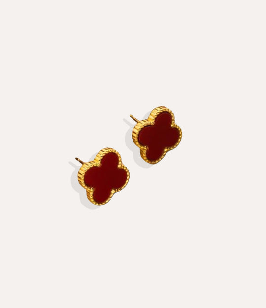 Product shot of the Clover Stud Earrings in a gold finish displaying the burgundy lucky four leaf design and warm metallic tone on a white background.