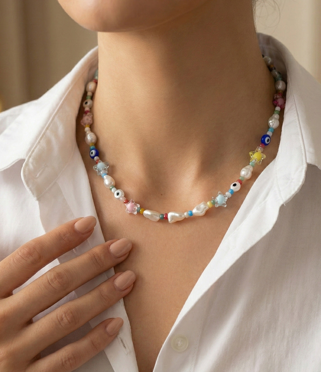 Necklace with colorful beads worn by a person in a white shirt