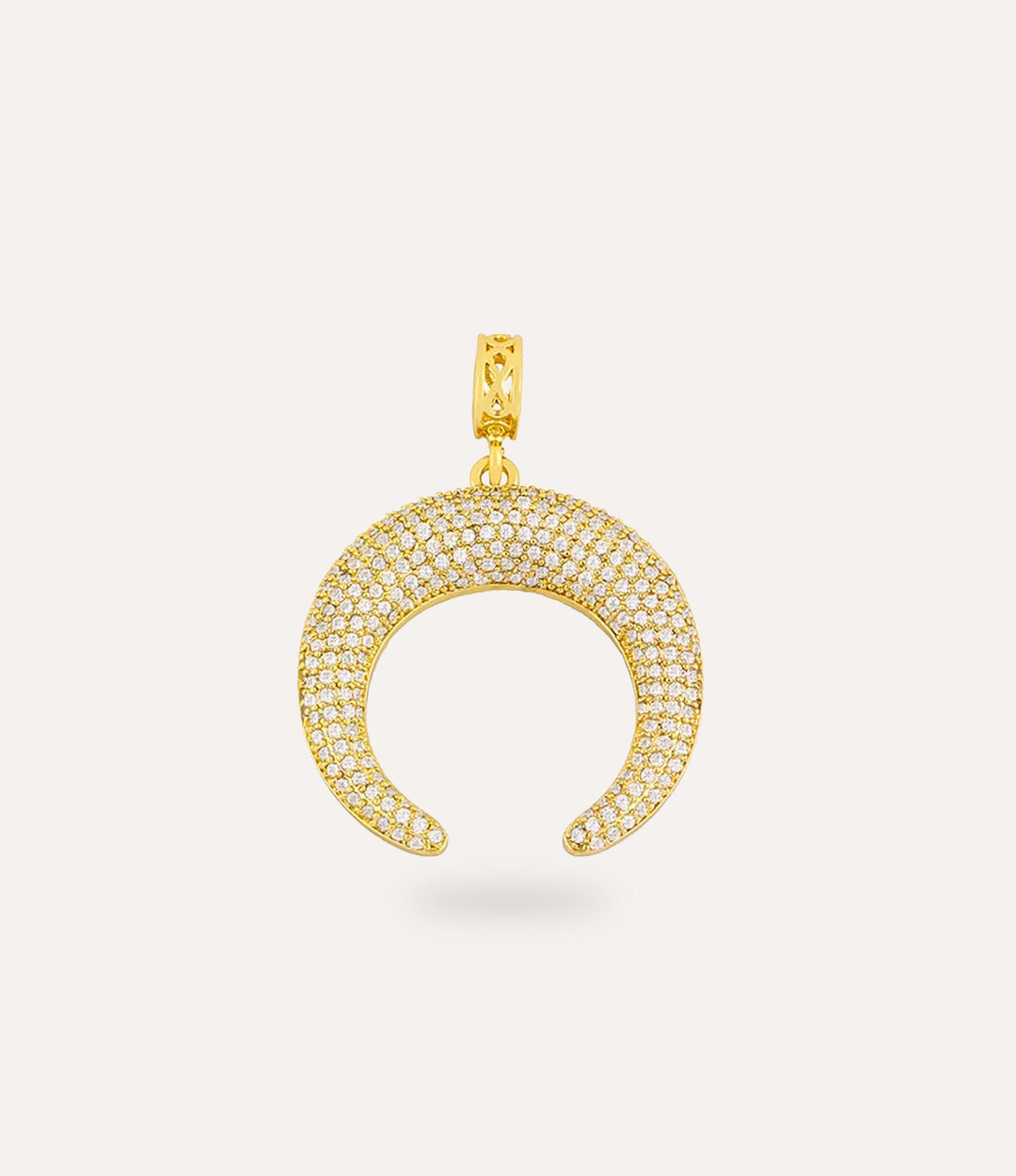 Gold crescent-shaped pendant with embedded stones on a light beige background