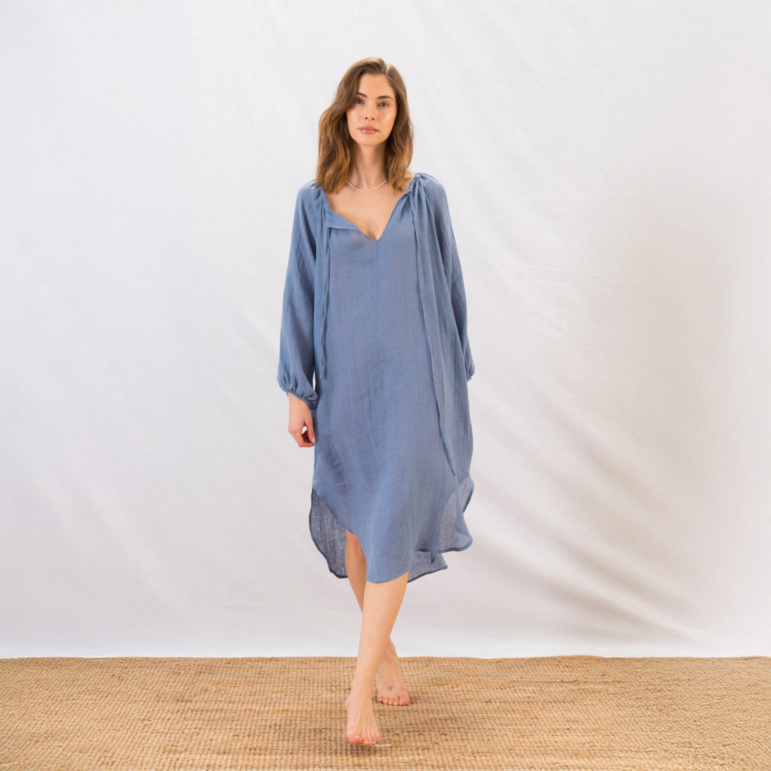 Woman wearing a blue dress standing on a white background
