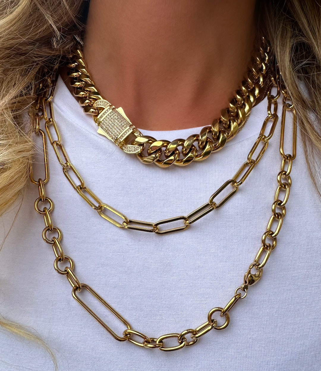 Styled photo of the 16-inch Cuban Diamond Clasp Necklace layered with other gold necklaces
