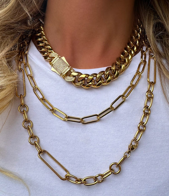 Styled photo of the 16-inch Cuban Diamond Clasp Necklace layered with other gold necklaces