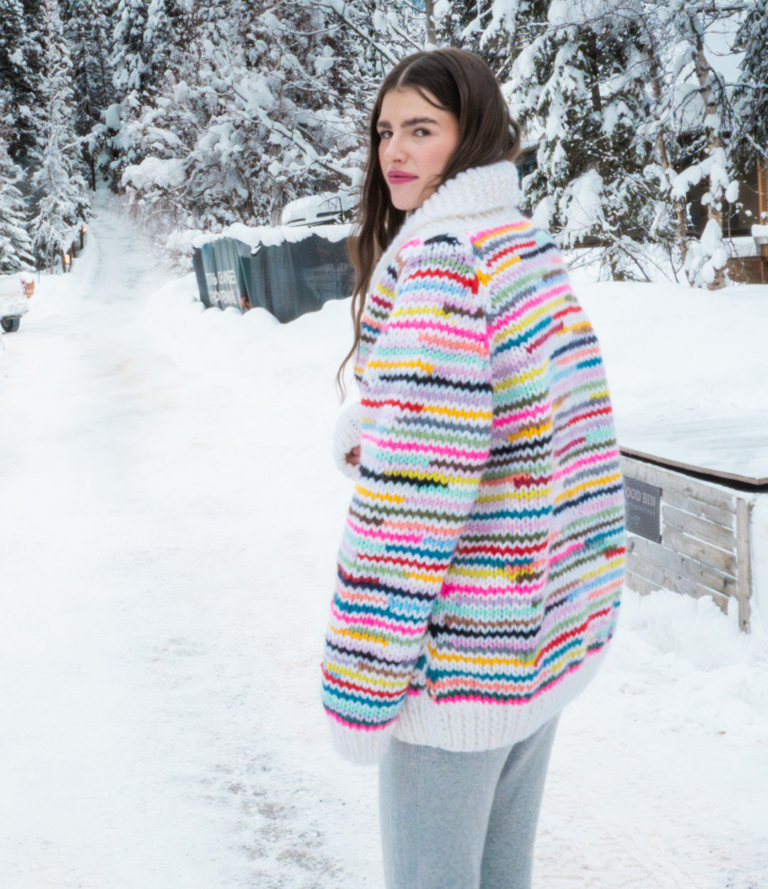 Woman wearing a colorful striped sweater in a snowy outdoor setting