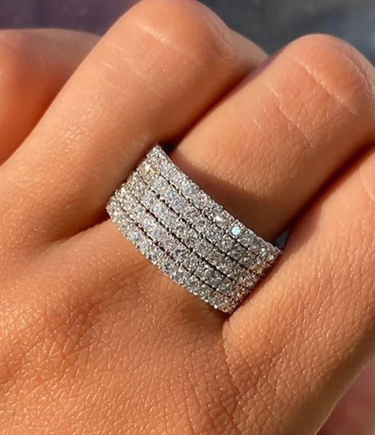 Woman's hand modeling the Dazzle Diamond Ring on the middle finger, showcasing the brilliant sparkle of the cubic zirconia stones in an editorial setting.