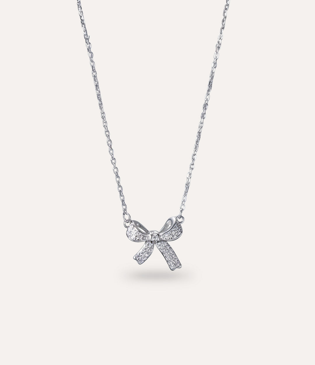 Dainty Delicate Bow Necklace in silver displayed on a neutral background.