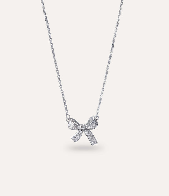Dainty Delicate Bow Necklace in silver displayed on a neutral background.