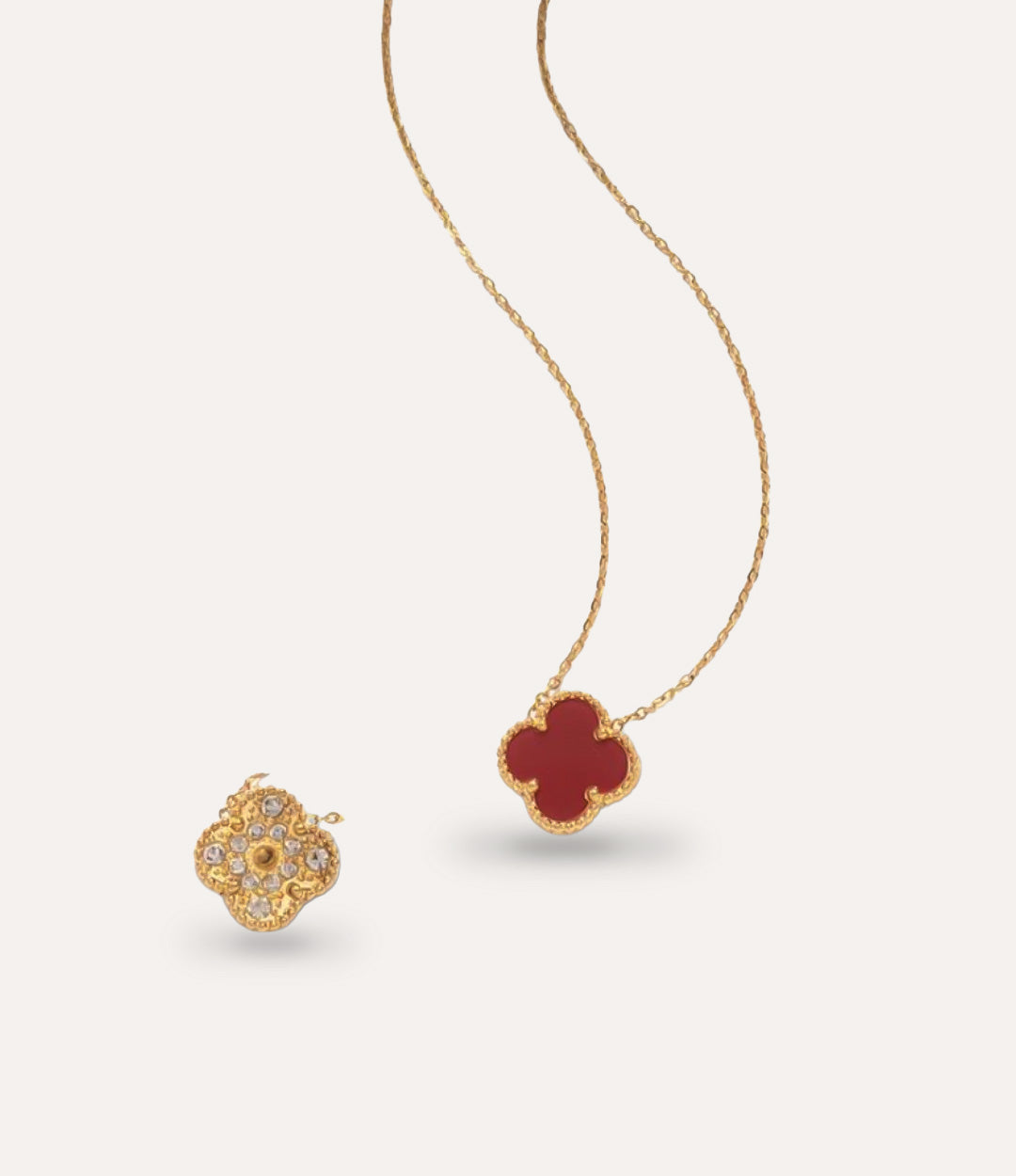 Close-up of waterproof gold and burgundy clover pendant with diamond details.