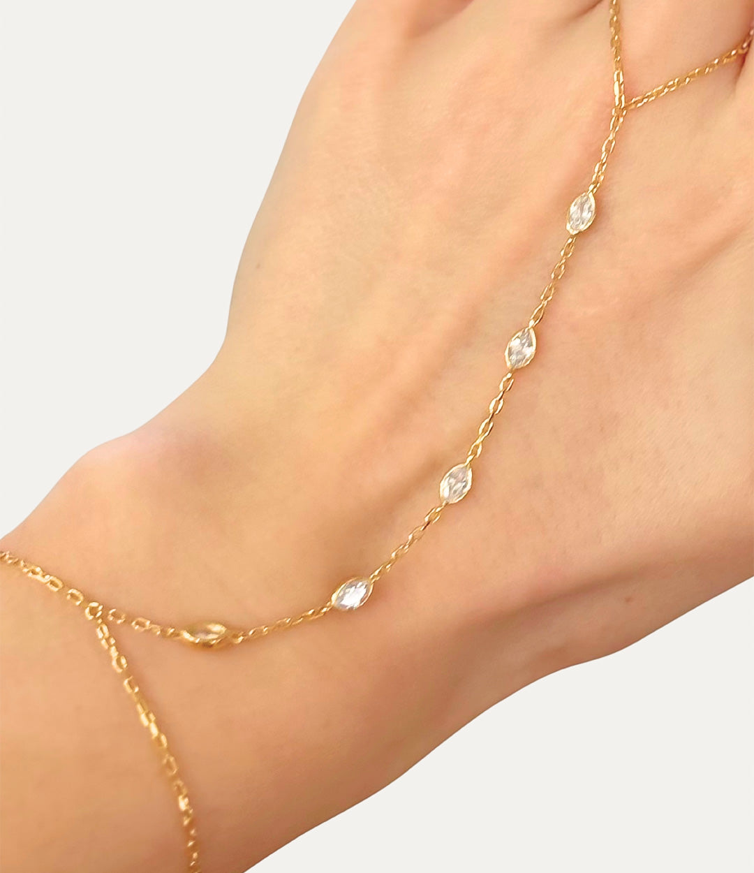 Diamond Oval Hand Chain in gold made of sterling silver with delicate diamond details displayed on a neutral background