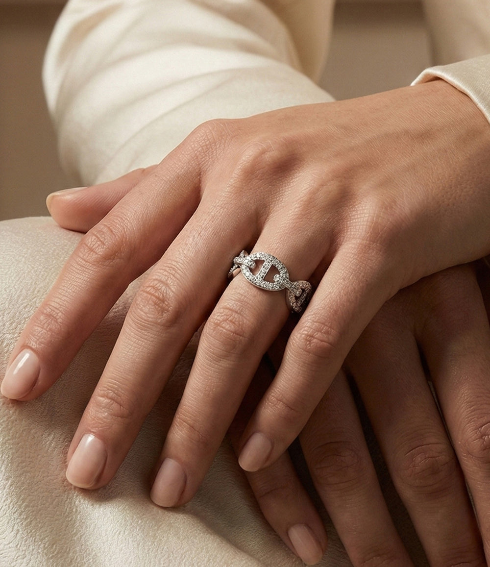 Woman's hand modeling the Diamond Link Ring alone on the ring finger, showcasing the bold chain-link design and subtle diamond sparkle against a neutral background.