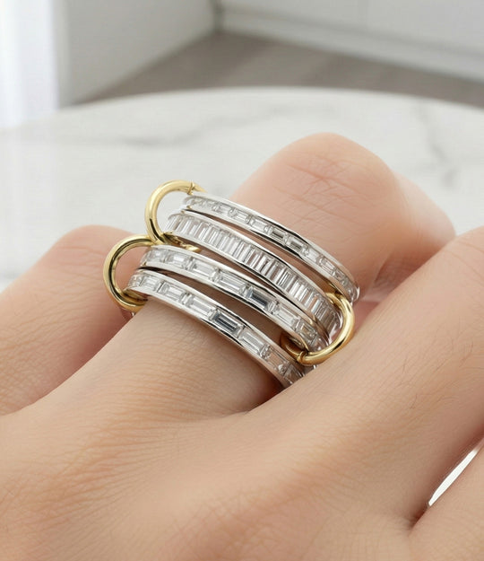 Three diamond rings on a finger with a neutral background