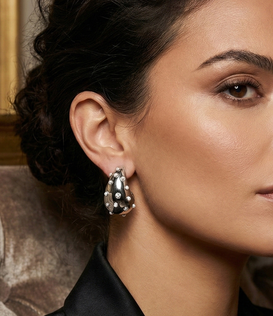 Close-up of a woman wearing a silver earring with a textured design.