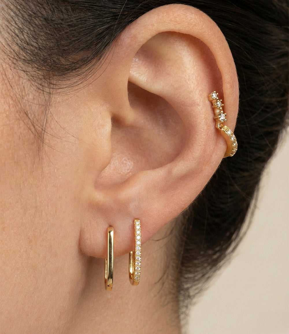 A woman wearing double diamond earrings