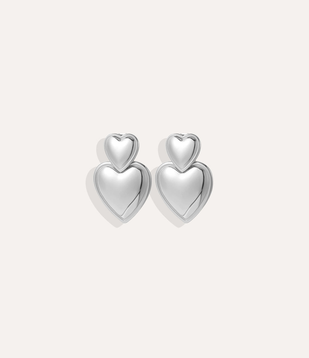 Product shot of the Double Heart Earrings in silver colour showing the cool stainless steel tone and double drop design on a white background.