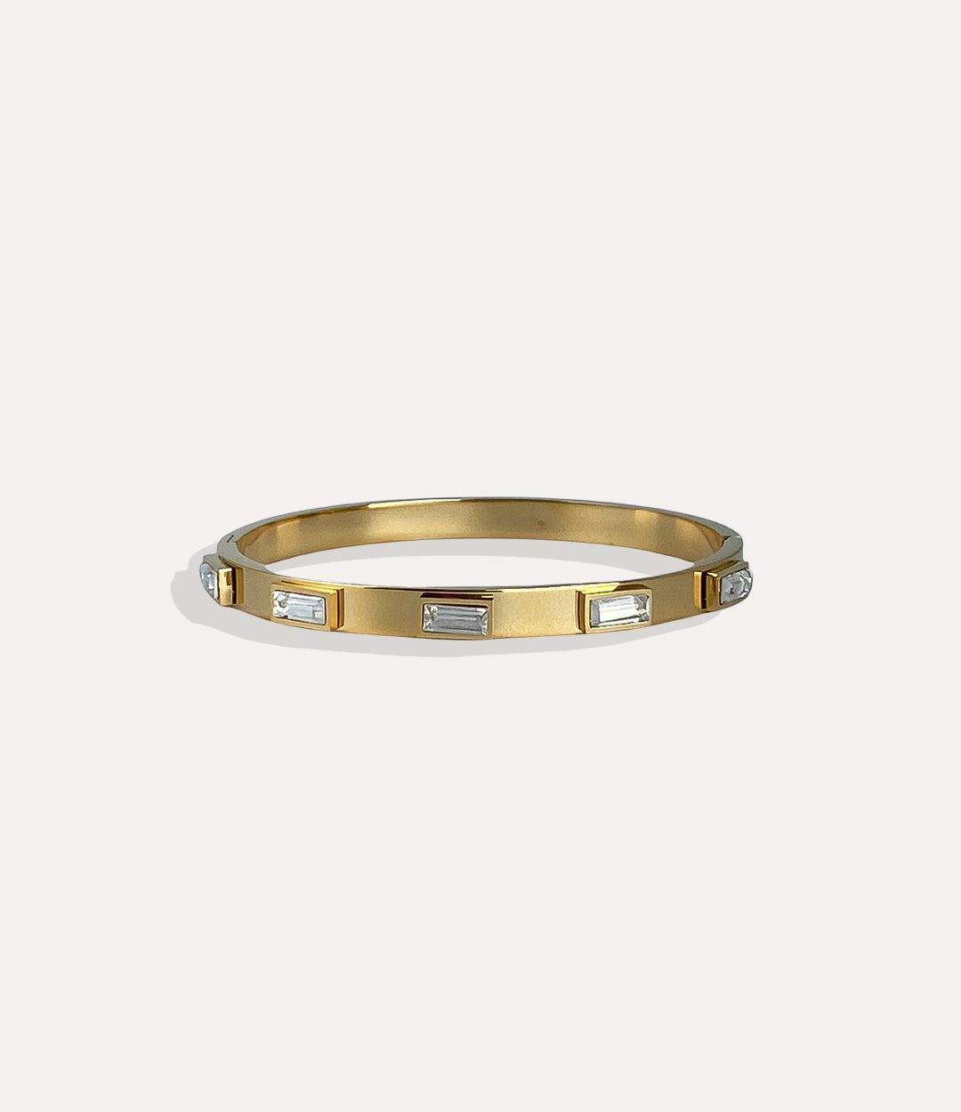 Gold bracelet with embedded stones on a white background