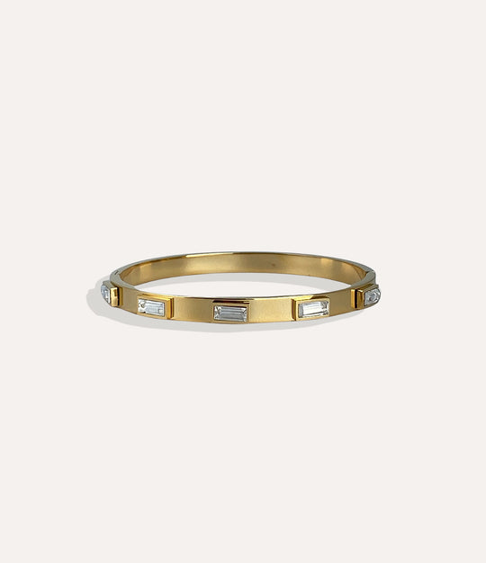 Gold bracelet with embedded stones on a white background