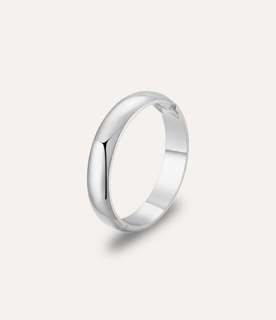 Essential Bangle in silver displayed on a neutral background with a sleek, minimalist bold design.