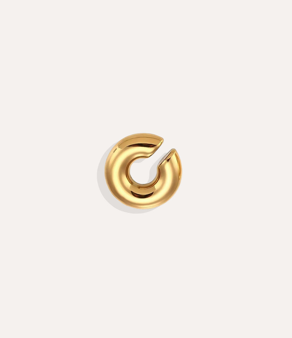 Product shot of the Essential Ear Cuff in gold tone displaying its smooth stainless steel finish and C-shaped design on a white background.