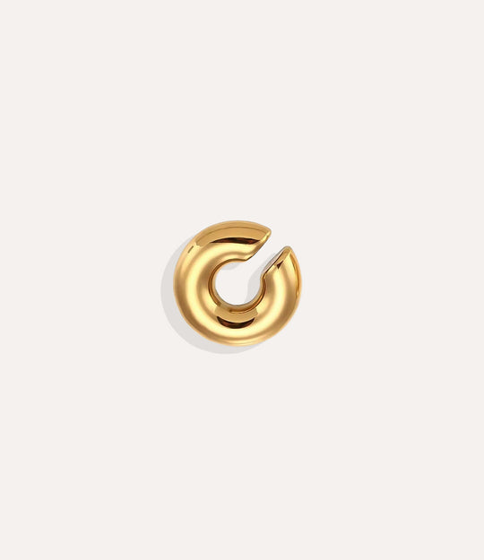 Product shot of the Essential Ear Cuff in gold tone displaying its smooth stainless steel finish and C-shaped design on a white background.
