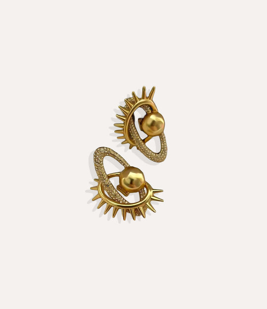Close up of the Eyelash Earrings in gold highlighting the detailed eyelash design and shimmering accents.