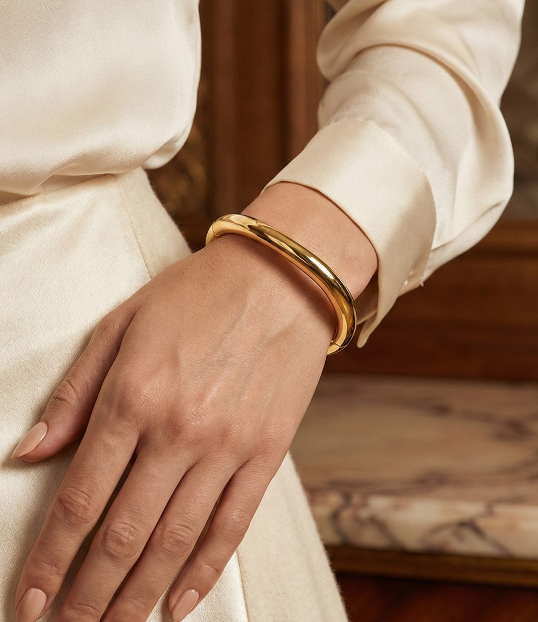 Gold bracelet on a wrist with a blurred background