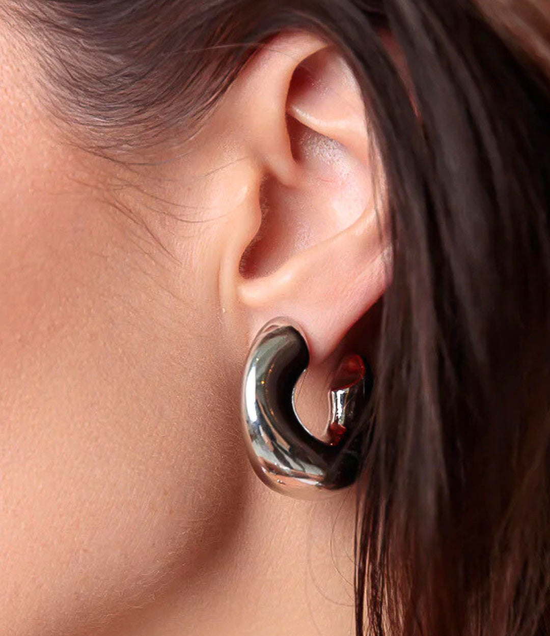 Close up of the Fluid Hoops in silver, featuring the unique fluid shape and sleek silver plating.